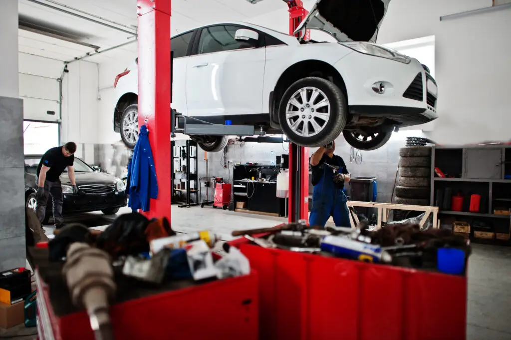 Car repair and maintenance theme. Mechanic in uniform working in auto service.